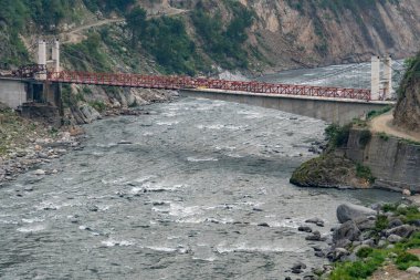 Hindistan 'ın Himachal Pradesh bölgesindeki Chamba Bölgesi' nin altından akan Ravi Nehri ile iki tepe arasında uzanan uzun bir köprü..