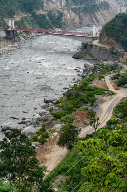 Hindistan 'ın Himachal Pradesh bölgesindeki Chamba Bölgesi' nin altından akan Ravi Nehri ile iki tepe arasında uzanan uzun bir köprü..
