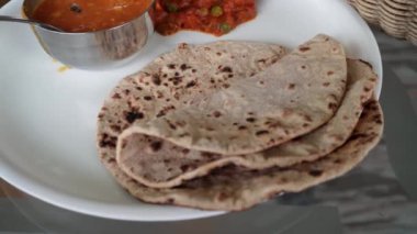 Yemek masasında servis edilen roti, dal ve karışık sebzelerden oluşan Kuzey Hindistan tabağı. Hindistan 'ın Himachal Pradesh kentindeki yolculukta keyifli geçen sağlıklı yemek yerel mutfağın tadına varmamızı sağlıyor..
