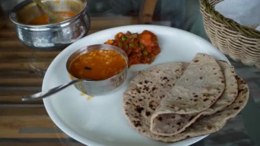 Yemek masasında servis edilen roti, dal ve karışık sebzelerden oluşan Kuzey Hindistan tabağı. Hindistan 'ın Himachal Pradesh kentindeki yolculukta keyifli geçen sağlıklı yemek yerel mutfağın tadına varmamızı sağlıyor..