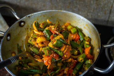 Hint mutfağında pişirilen sebzeler, otlar ve baharatlarla harmanlanmış sıcak buharlı bamya. Hint mutfağı ve yemek hazırlama stok görüntüleri için mükemmel..