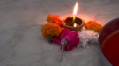 Navratri boyunca canlı çiçeklerle çevrili yanan bir çamur lambası (diya), Hint tanrıçalarını onurlandıran bir Hindu festivali. Uttarakhand, Hindistan 'da yakalandı..