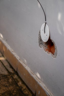 Kablo kabloları ve fiber optik kurulumu için bir duvarda büyük bir delik açılmış tuğla deliklerini gösteriyor, Hindistan 'ın Dehradun şehrindeki kentsel gelişimi temsil ediyor..