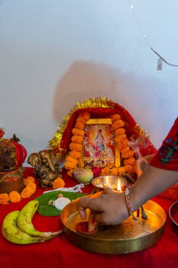 A burning mud lamp (diya) surrounded by vibrant flowers during Navratri, a Hindu festival honoring Indian goddesses. Captured in Uttarakhand, India. clipart