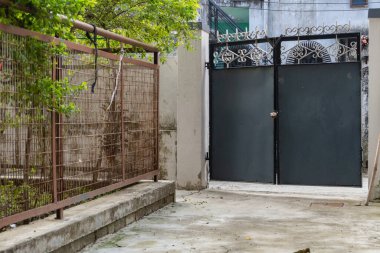 Bağımsız bir Hint evinde metal bir kapısı olan arka bahçenin huzurunun tadını çıkarın. Kümesiz yaşam ve güvenli dış duvarlar..