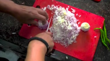 Profesyonel bir soğan doğrama ustalığını bir bıçakla yakalayın, otantik bir Hint evinde ayarlayın, kesim becerilerini vurgulayın..