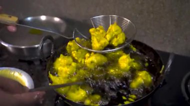 Hint usulü kızartılmış sebzeli pakoraların geleneksel karışımını deneyin. Hint usulü abur cubur. Hint usulü otantik bir evde bulunan dökme demir bir kapta sıcak ayçiçeği yağı ile hazırlanıyor..