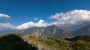 Uttarkashi, Uttarakhand 'de Raithal üzerinde sürüklenen ve Gangotri kuşağının görkemli dağlarını ve buzul zirvelerini gözler önüne seren bulutların nefes kesici geniş açılı zamanlamasını deneyimleyin..