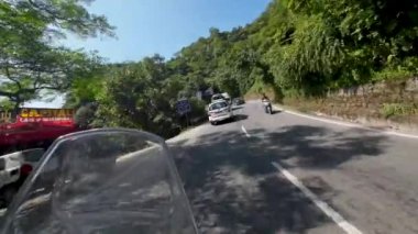 Uttarakhand Hindistan, 29 Aralık 2024. Manzaralı Mussoori-Dehradun otoyolunda bisiklet sürmenin heyecanını yakalayın, aksiyon kamerası görüntülerinde turist otobüsleri ve arabaların yer aldığı.