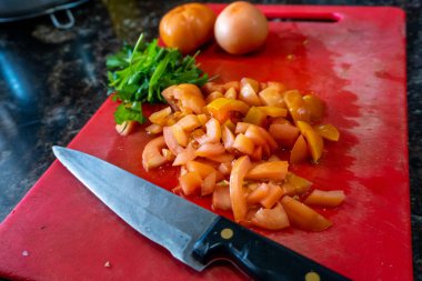 Kuzey Hindistan mutfağında domatesler ve doğranmış bıçakların olduğu masa üstü manzarası, sağlıklı köri hazırlıklarını betimliyor..