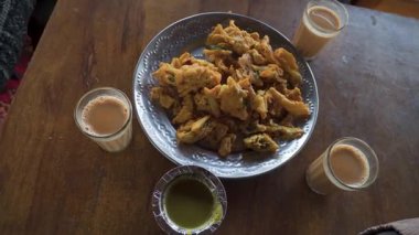 Hindistan, Uttarakhand, Dehradun 'daki yol kenarındaki bir restoranda yeşil biber soslu sıcak pakoralar ve çay..