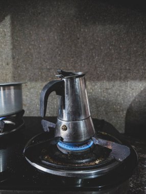 Sobanın üstünde bir moka demliği, ünlü Güney Hindistan kahvesi ile filtre kahve hazırlıyor. Güne Hindistan 'da başlamak için sabah espresso shot' ı.