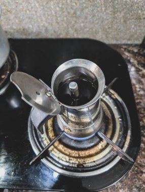 Sobanın üstünde bir moka demliği, ünlü Güney Hindistan kahvesi ile filtre kahve hazırlıyor. Güne Hindistan 'da başlamak için sabah espresso shot' ı.