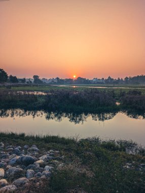 Doğu Yamuna Kanalı ve Asan Nehri, Uttarakhand, Hindistan 'ın kesişiminde yer alan turuncu gökyüzü ve geniş doğal manzarasıyla Asan Barrage, Dehradun üzerinde görkemli bir gün doğumu..