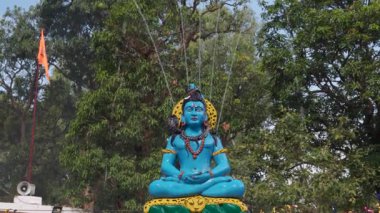 1 Mart 2025, Dehradun Hindistan. Uttarakhand, Hindistan 'daki Mahashivratri festivali sırasında Ganga' yı yukarıdan yansıtan bir çeşme serpiştirilmiş güzel bir Lord Shiva mavi taş heykeli..