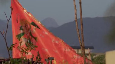 30 Mart 2025, Dehradun Şehri Uttarakhand Hindistan. Hindistan 'da Uttarakhand, Hindistan' da dağları olan Kuzey Hindistan 'daki bir evin çatısında sallanan Tanrı Hanuman' ın sanat eserlerinin olduğu Hint bayrağı..