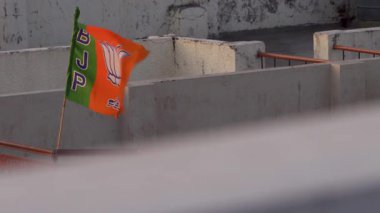 30 Mart 2025, Dehradun Şehri Uttarakhand Hindistan. Bharatiya Janata Partisi (BJP) seçimler sırasında yerel bir Hint kasabasının çatısında dalgalanan bayrak, siyasi coşkuyu simgeliyor.