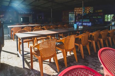 17 Nisan 2025, Dehradun Uttarakhand Hindistan. Hindistan 'da ulusal bir karayolu boyunca yol kenarında oturan plastik sandalyeler ve masa..