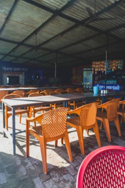 17 Nisan 2025, Dehradun Uttarakhand Hindistan. Hindistan 'da ulusal bir karayolu boyunca yol kenarında oturan plastik sandalyeler ve masa..