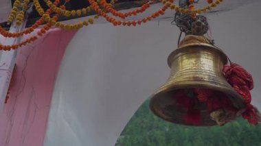 20 Mayıs 2025, Uttarakhand Hindistan. Uttarakhand 'da saygı duyulan bir Hindu hac alanı olan Gangotri Dham' da geleneksel kırmızı kutsal örtüye sarılı büyük bir tapınak çanı..