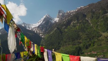 Harsil Vadisi, Uttarkashi 'deki görkemli ikiz tepeler, karla örtülmüş, Tibet bayrakları ile süslenmiş, Lama Tepesi