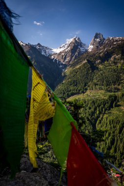 Harsil Vadisi, Uttarkashi 'deki görkemli ikiz tepeler, karla örtülmüş, Tibet bayrakları ile süslenmiş, Lama Tepesi