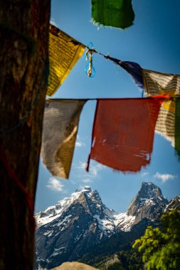 Harsil Vadisi, Uttarkashi 'deki görkemli ikiz tepeler, karla örtülmüş, Tibet bayrakları ile süslenmiş, Lama Tepesi