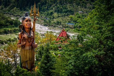 Himalaya bölgesindeki Lord Shiva 'nın heykeli kutsal Bhagirathi Nehri' nin üzerinde duruyor. Ganj nehri..