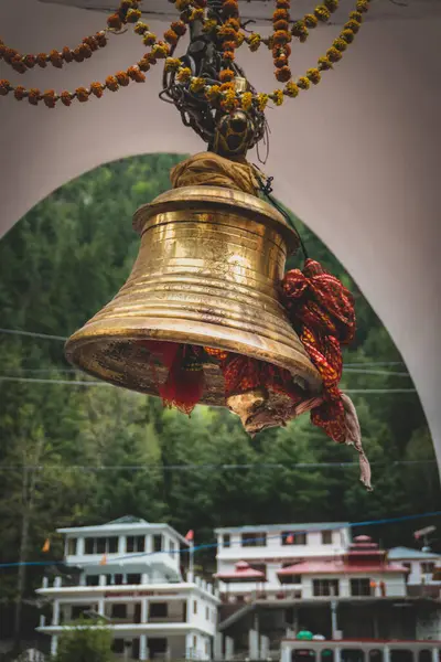 20 Mayıs 2025, Uttarakhand Hindistan. Uttarakhand 'da saygı duyulan bir Hindu hac alanı olan Gangotri Dham' da geleneksel kırmızı kutsal örtüye sarılı büyük bir tapınak çanı..