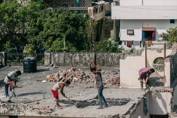 23 Ocak 2025 Dehradun Şehri Uttarakhand Hindistan. Günlük işçi maaşı yeni şehir konutları için çekiçli evleri söküyor. Hindistan 'ın aşırı nüfuslu Dehradun kentindeki şehir gelişimi.