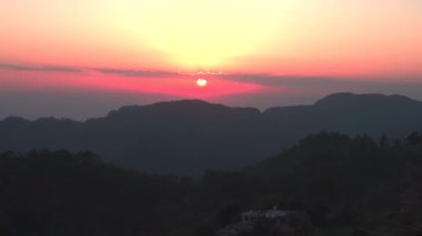 Hindistan 'ın Uttarakhand kasabası Kimadi köyü yakınlarındaki Dehradun tepeleri üzerindeki bulutlarla panoramik günbatımı