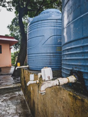 2 Temmuz 2025 Dehradun Uttarakhand Hindistan. Dışarıdaki beton platformda iki büyük mavi su tankı..