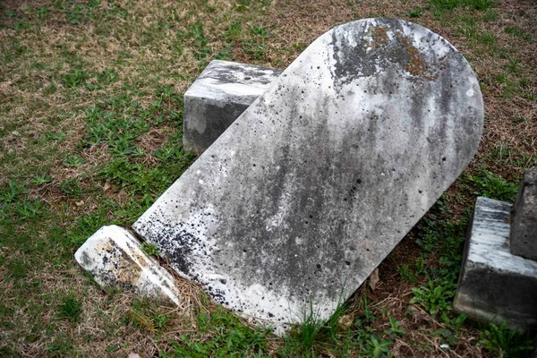 Zielona Trawa Częściowo Zakopuje Spadający Kamień Grobowy Starożytnym Cmentarzu Wiosennym — Zdjęcie stockowe