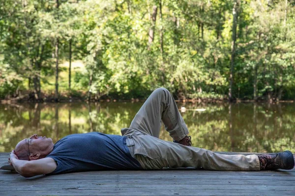 Homem Caucasiano Sênior Descansa Sozinho Meditando Por Lago Calmo Uma — Fotografia de Stock