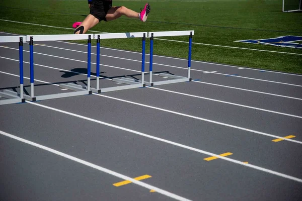 Ein Läufer Bei Einem Rennen Auf Einer Leichtathletikbahn Springt Über — Stockfoto