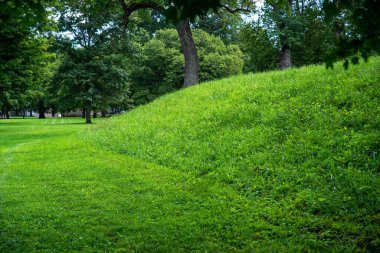 Ohio 'daki tarih öncesi yerli halk tarafından inşa edilen Newark Dünya Fabrikası' ndaki Büyük Çember 'in dış cephesi. Yeşil çimenler, gölge ağaçları, güneşli açık havada insan yok ve kopyalama alanı var. Höyük yapısının yakın görüntüsü.