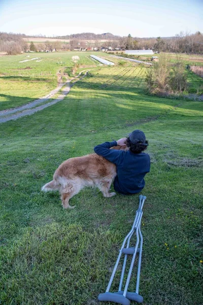 与一位年轻人和他心爱的金发碧眼的猎犬漫步在一座长满青草的小山上 俯瞰着一条金光闪闪的天然山路 复制着空间 — 图库照片