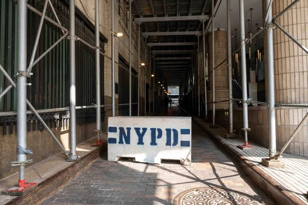 ニューヨーク市警察署道路ブロックの両側に歩道をカバー足場と暗い側の通りを横断 都会の風景 白いバリケードにニューヨーク市警が描いた — ストック写真