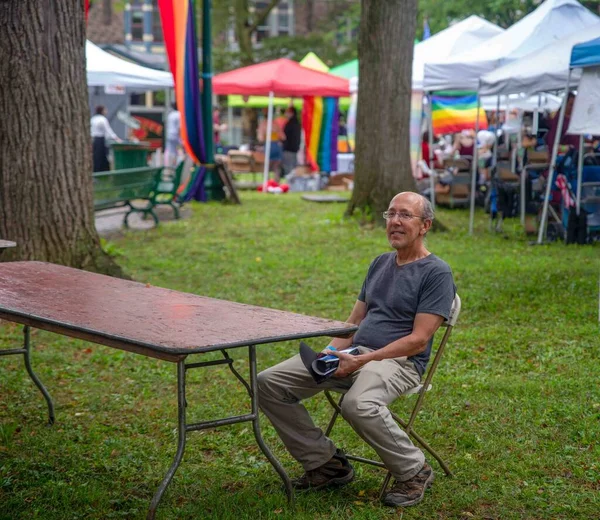 Hombre Sonriente Sienta Solo Relajándose Pride Fest Reading Con Banderas — Foto de Stock