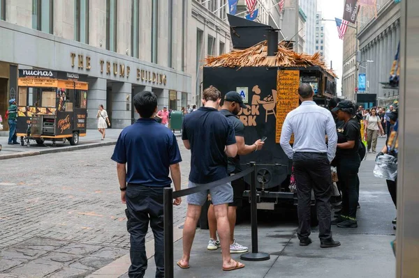 ニューヨーク ニューヨーク 2023 観光客やビジネスの人々のグループは マンハッタン市のトランプビルディングの前にジャムロックジャークフードトラックに並んでいます 編集のみを使用する — ストック写真