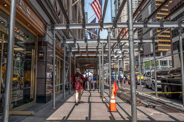 ニューヨーク ニューヨーク 2023 歩行者は タクシー 高層ビルが付いている賑やかな都市のストリートシーンの金属の足場の下を歩きます 編集は使用だけ — ストック写真