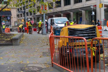 New York, New York, ABD 12-04-2023 Güvenlik yelekleri giyen ve Manhattan inşaat yolu bakım sahasında çalışan işçiler