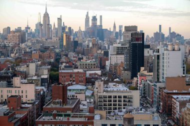 New York, New York, ABD 11-09-2023 Pembe gökyüzü ve New York şehrinin havadan bakıldığında Manhattan 'a bakan manzarasında altın saat gün batımı. Sokak sanatı ve trafik görünür. Boşluğu kopyala.