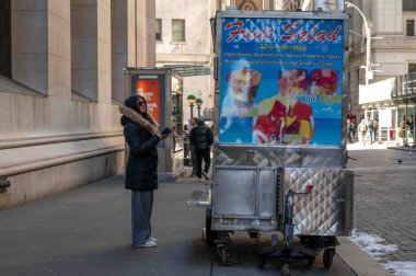 New York, New York, ABD 02-20-2023 Manhattan caddesinde bir kadın müşteriyle meyve salatası satıcısı. Sadece editör kullanımı