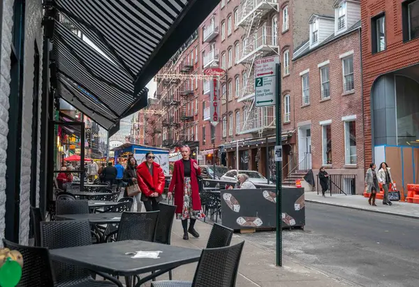纽约街上的时尚步行者们在外面的人行道上走过壁画式的餐桌 砖楼的消防背景 小意大利街道装饰 — 图库照片