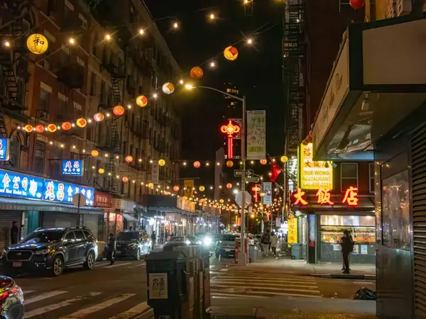 チャイナタウン ニューヨーク ニューヨーク 2023 ナイトシーン チャイナタウン カラフルな装飾を持つNyストリート 通りやレストランの上の中国のランタン 歩道を横切る車の人々とのレストランのサイン エディトリアル使用 — ストック写真