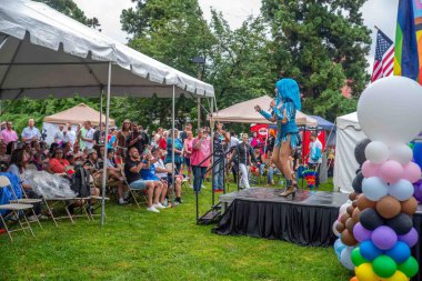 Okuyorum, Pa USA 08-22-2021 Okuma Onur Festivali Sürükleme Sanatçısı açık havada sahnede büyüleyici mavi kostümlü ve kalabalık çadırların altında seyirci ile. Gökkuşağı balonları ve bayraklar. Sadece editör kullanımı
