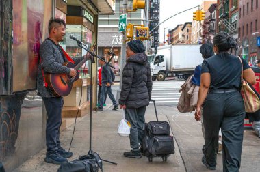 New York, New York, ABD 05-15-2024 Çin Mahallesi genç gitarist müzisyen sokak pozitif duyguları için mikrofonla şarkı söylüyor.