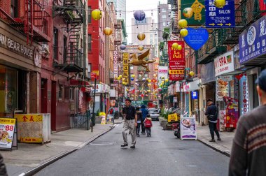Çin Mahallesi, New York, New York, ABD 05-15-2024 fenerli renkli süslemeler ve caddenin yukarısında renkli tabelalı uçan bir at, yayalar, şehir caddesinde iş yerleri. Sadece editör kullanımı.