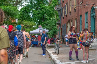 Philadelphia, PA USA, 06-02-2024 İnsanlar geçerken Onur Festivali 'nde oy kullanmak için kayıt tutuyor. Eski tuğla evler kaldırım ağaçları ve yayalar sokak panayırları ve masalar